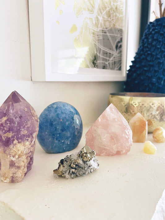 Citrine, amethyst, agate,Rose quartz, citrine and pyrite on a mantle with a gold bowl