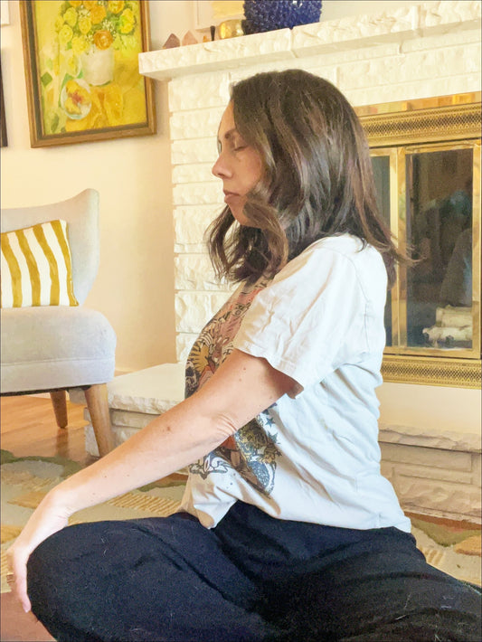 Woman doing a seated twist for somatic release and nervous system healing